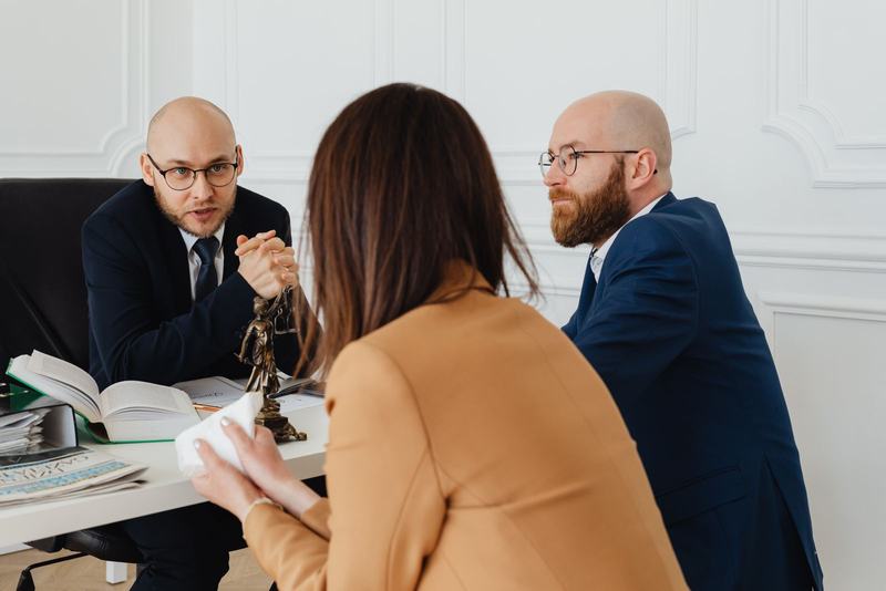 Advogado conversando com uma cliente sobre documentos em uma mesa